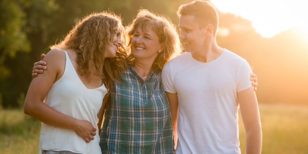 mom and two children in a sunlit field