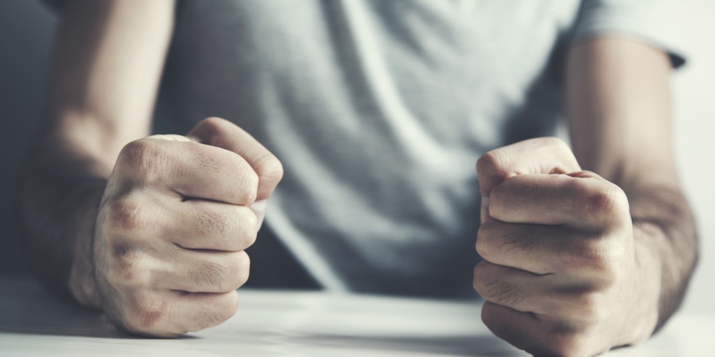person banging both fists on table