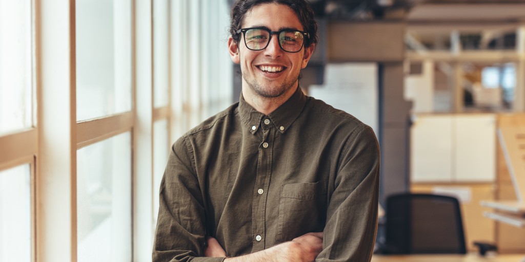 smiling young man with arms crossed