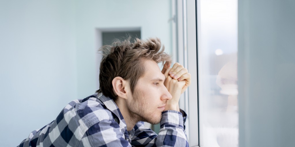 man gazing out a window pensively