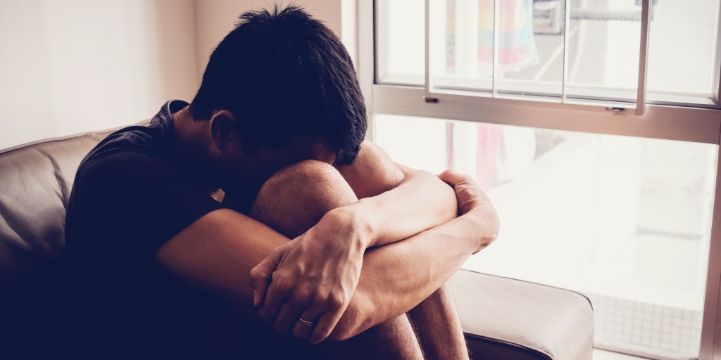 young man holding knees to face dealing with ocd and anxiety