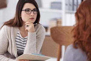 a woman talks to a therapist at a somatic experiencing program in tx