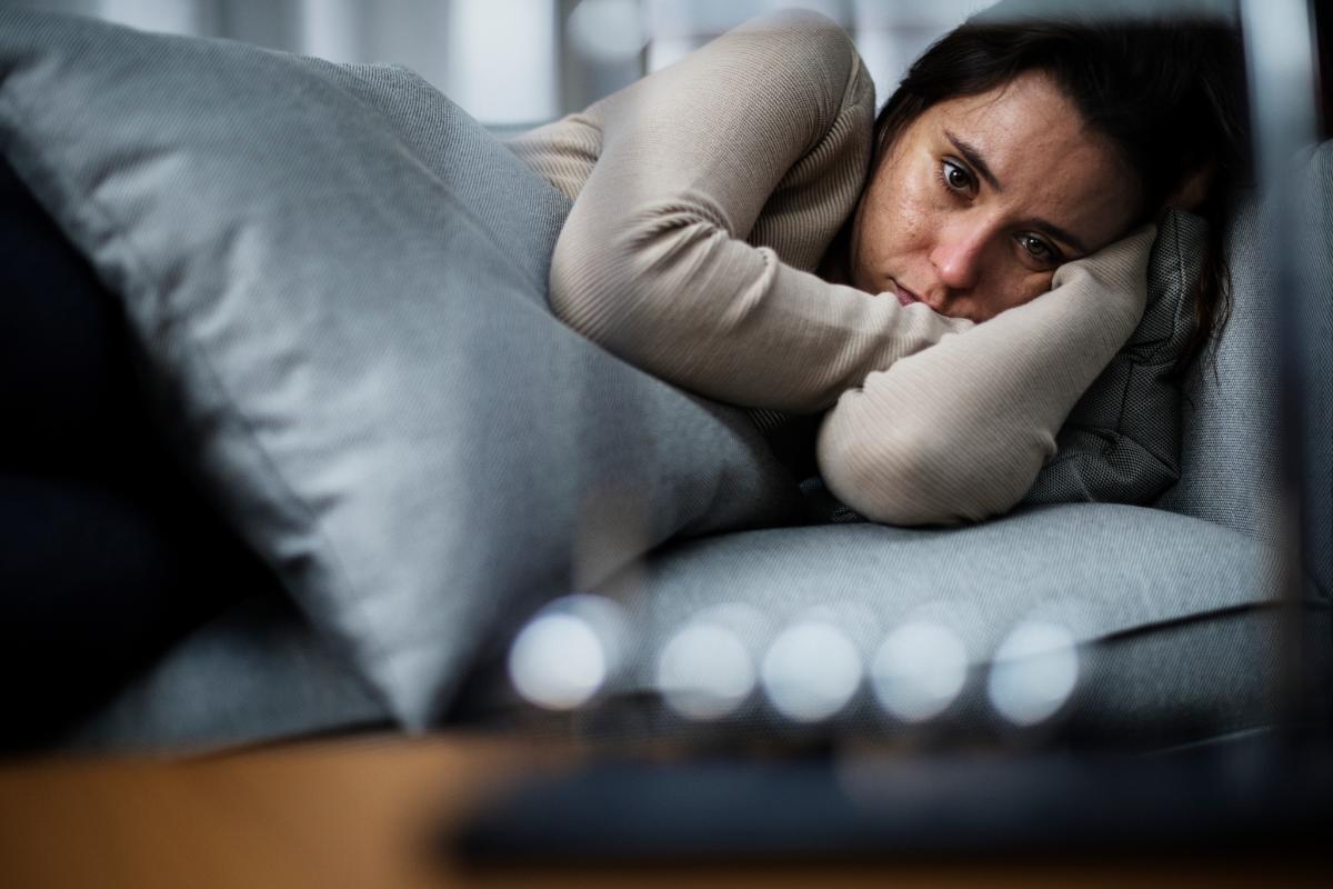 depressed woman in bed who could benefit from addressing trauma in substance abuse treatment